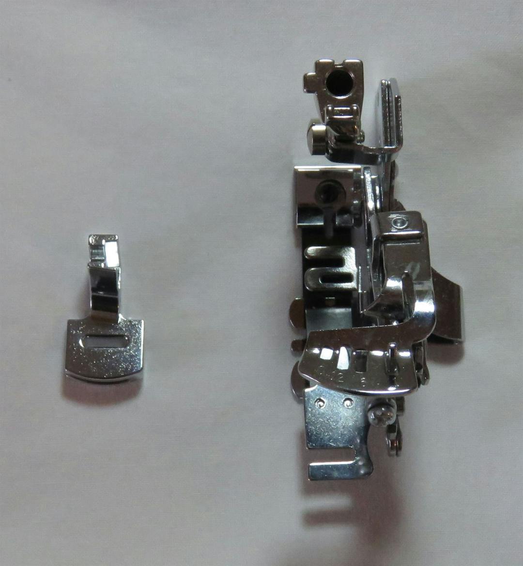 Photo of two specialty sewing machine feet for gathering fabric, the gathering foot and the ruffler