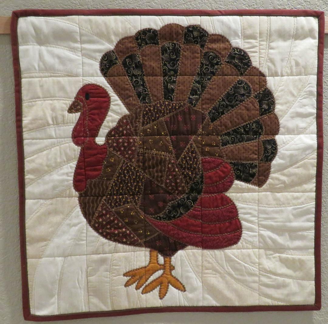 Photo of finished turkey quilt wall hanging with red and brown flange binding