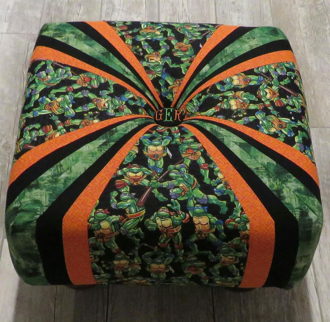 Completed square tuffet with Mutant Ninja Turtles focal fabric and orange, green and black fabric corners